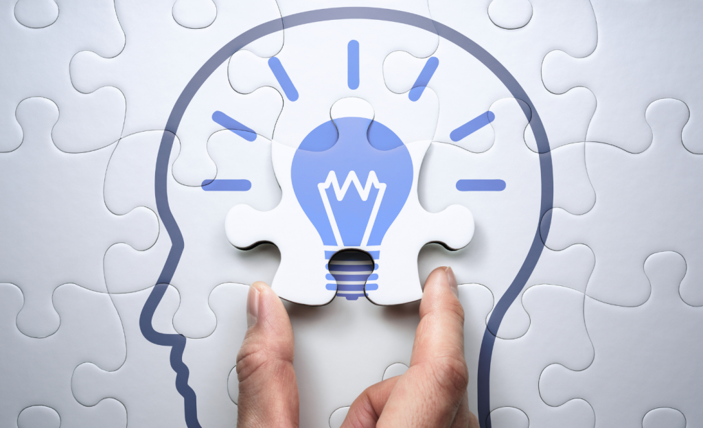 Puzzle pieces completing a light bulb in the brain graphic