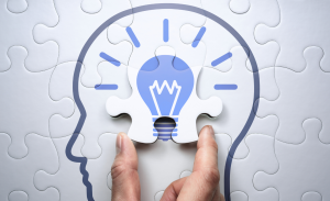 Puzzle pieces completing a light bulb in the brain graphic
